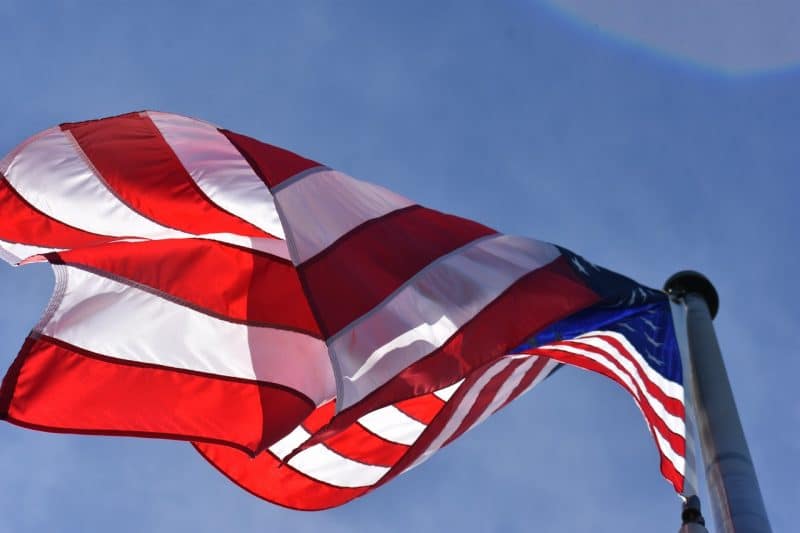 An American flag waves in the sky. Image used by One America News for an interview with T.W. Arrighi.