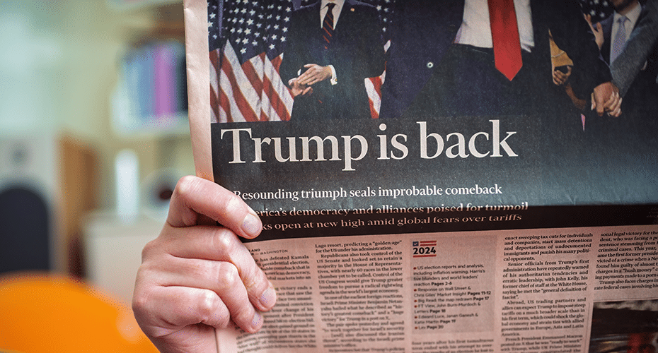 Person holding the newspaper with an article headlined 